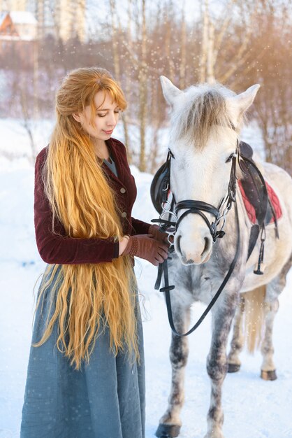 Mulher jovem, com, cabelo longo, com, cavalo, em, inverno