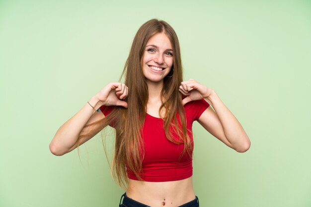 Mulher jovem, com, cabelo longo, sobre, isolado, parede verde, orgulhoso, e, self-satisfied