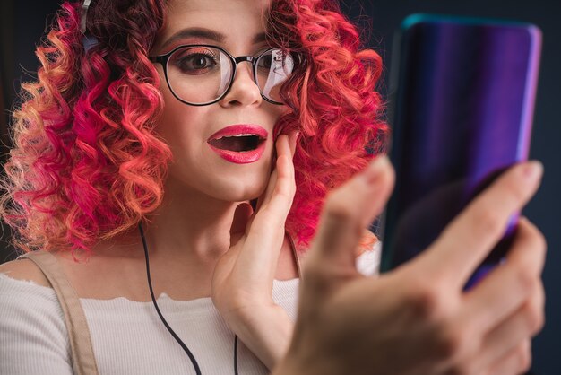 Mulher jovem com cabelo ruivo brilhante Conteúdo de choque do smartphone