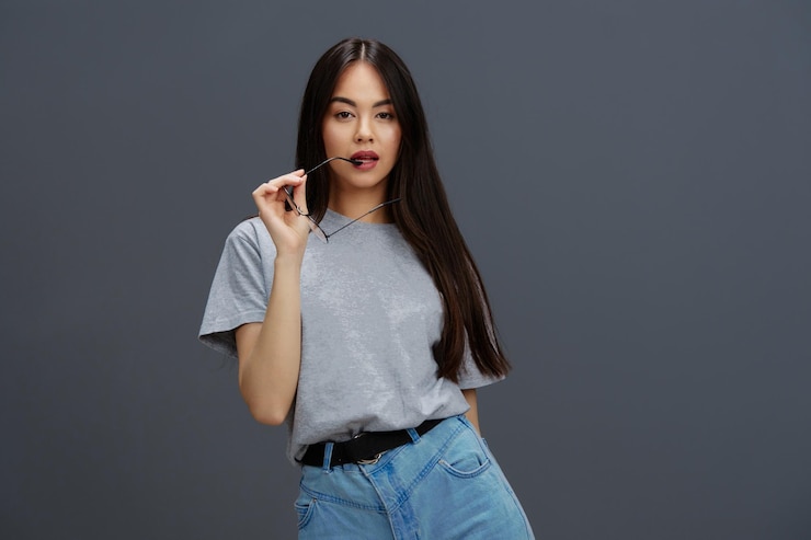 Foto mulher jovem com cabelos longos em uma camiseta cinzenta gesticulando com as mãos isolado fundo foto de alta qualidade