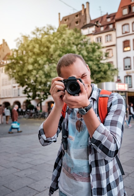 Mulher jovem com câmera fotografando na rua