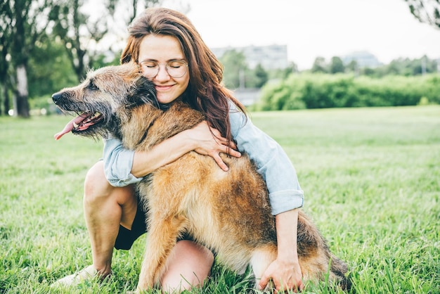 Mulher jovem com cão no campo