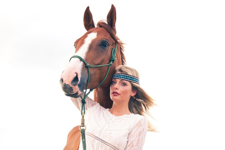 Foto mulher jovem com cavalo contra o céu claro