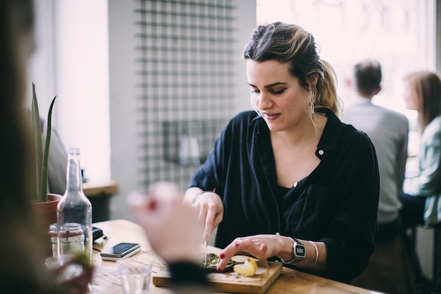 Mulher jovem com comida na mesa de um restaurante