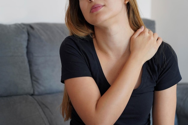 Mulher jovem com dor no ombro Menina com torcicolo chato e conceito de dor postural