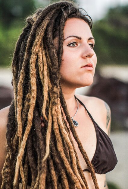 Foto mulher jovem com dreadlocks olhando para longe