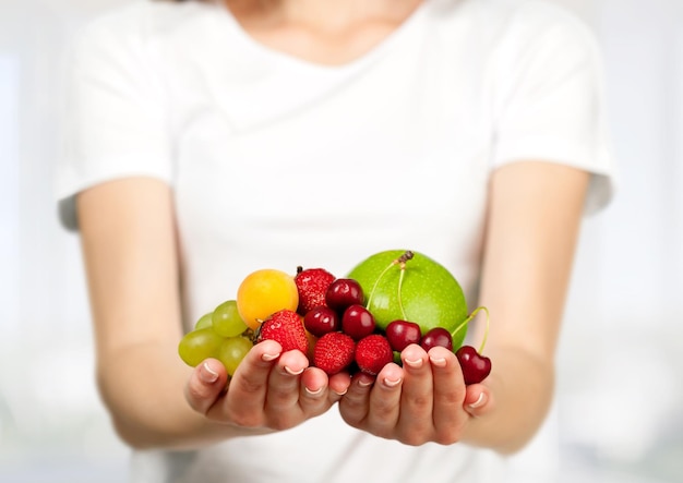 Mulher jovem com frutas nas mãos