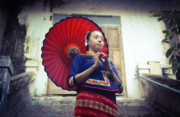 Foto mulher jovem com guarda-chuva vestindo roupas tradicionais