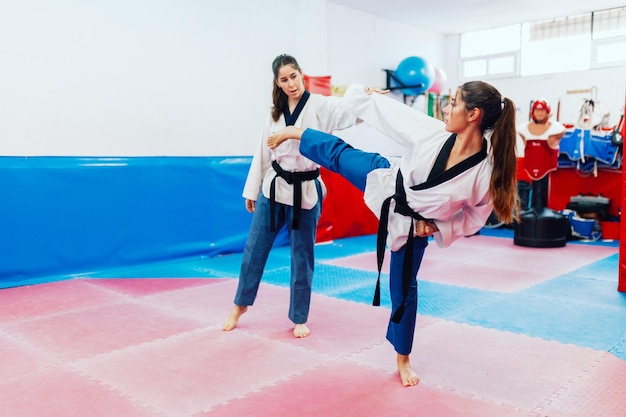 Foto mulher jovem com instrutor a praticar artes marciais.