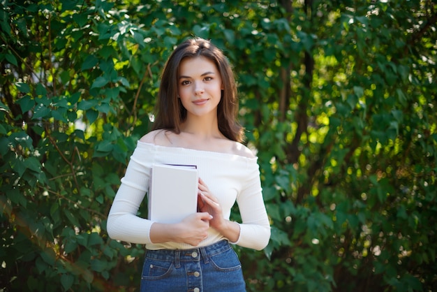 Mulher jovem com livros no parque