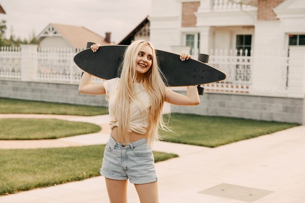 Mulher jovem com longboard na rua