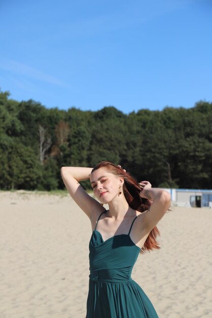 Mulher jovem com longos cabelos ruivos na praia