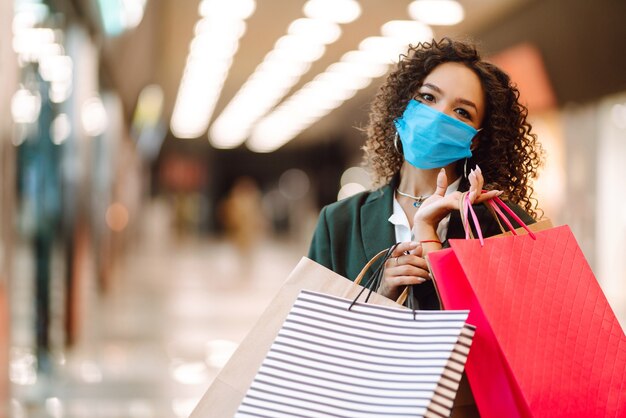 Mulher jovem com máscara de proteção contra coronavírus, depois de fazer compras.