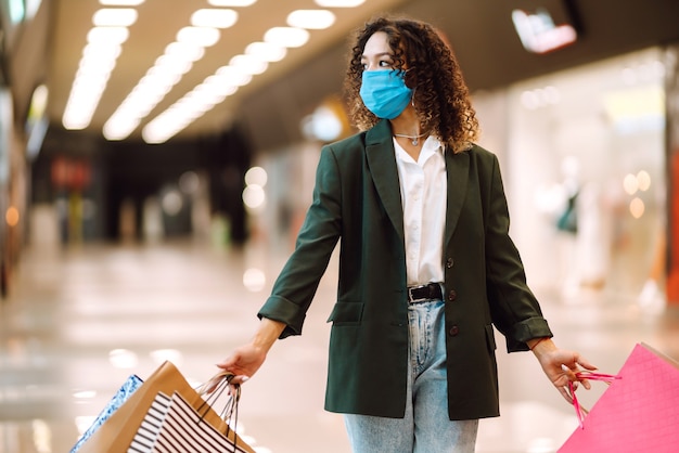 Mulher jovem com máscara de proteção contra coronavírus, depois de fazer compras.