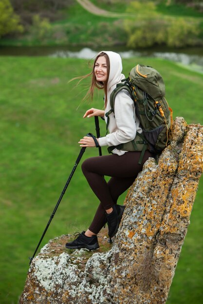 Mulher jovem com mochila caminhando nas montanhas conceito de caminhada penhascos de caminhada viajante de viagem