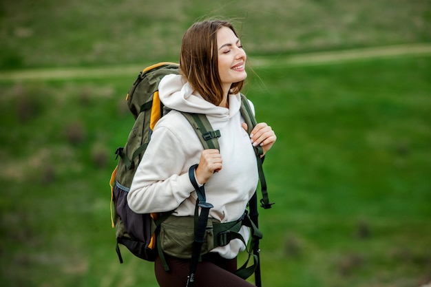 Mulher jovem com mochila caminhando nas montanhas conceito de caminhada penhascos de caminhada viajante de viagem