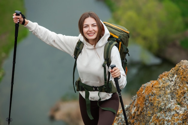 Mulher jovem com mochila caminhando nas montanhas conceito de caminhada penhascos de caminhada viajante de viagem