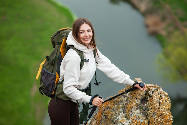 Foto mulher jovem com mochila caminhando nas montanhas conceito de caminhada penhascos de caminhada viajante de viagem