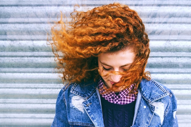 Foto mulher jovem com o cabelo encaracolado contra o obturador