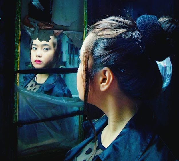 Foto mulher jovem com o reflexo no espelho
