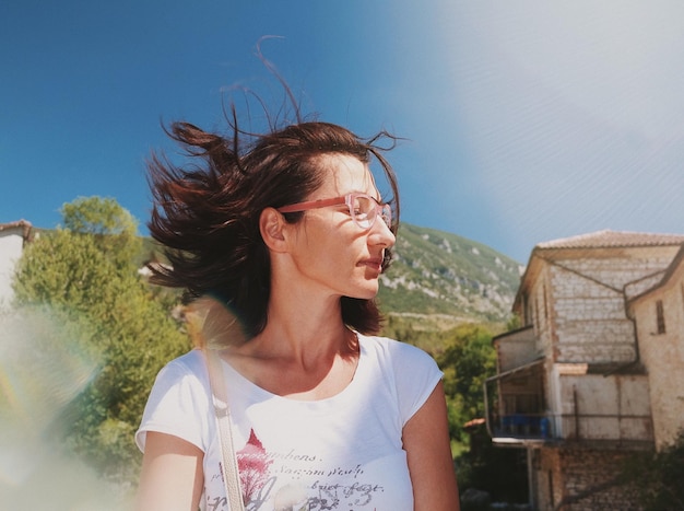 Mulher jovem com óculos de sol contra o céu