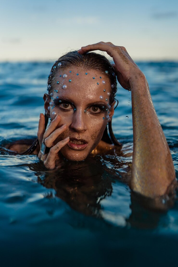 Foto mulher jovem com pele dourada na água