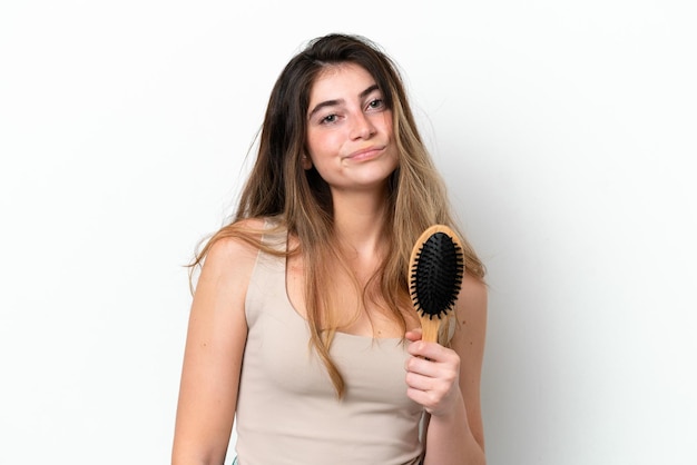 Mulher jovem com pente de cabelo isolado em fundo branco com expressão triste