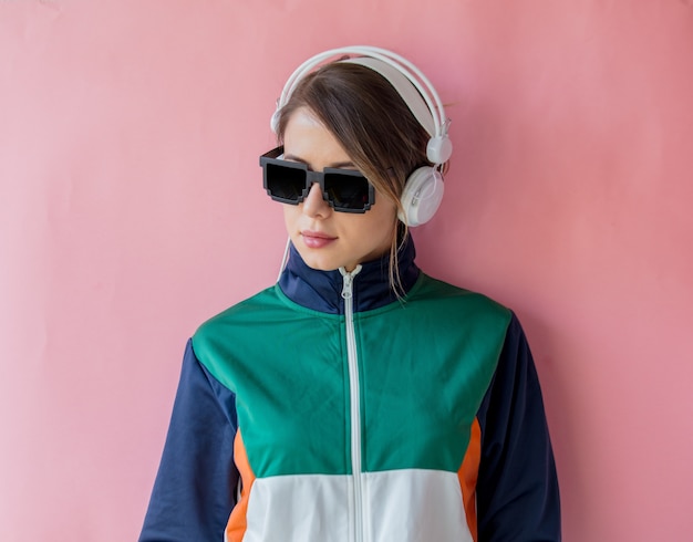 Mulher jovem com roupas estilo anos 90 com fones de ouvido rosa