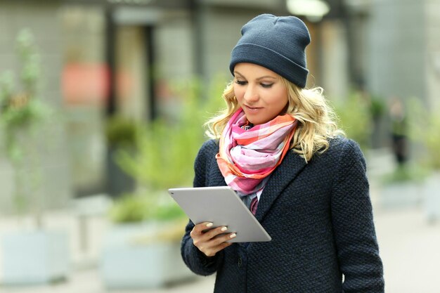 Mulher jovem com tablet na rua da cidade