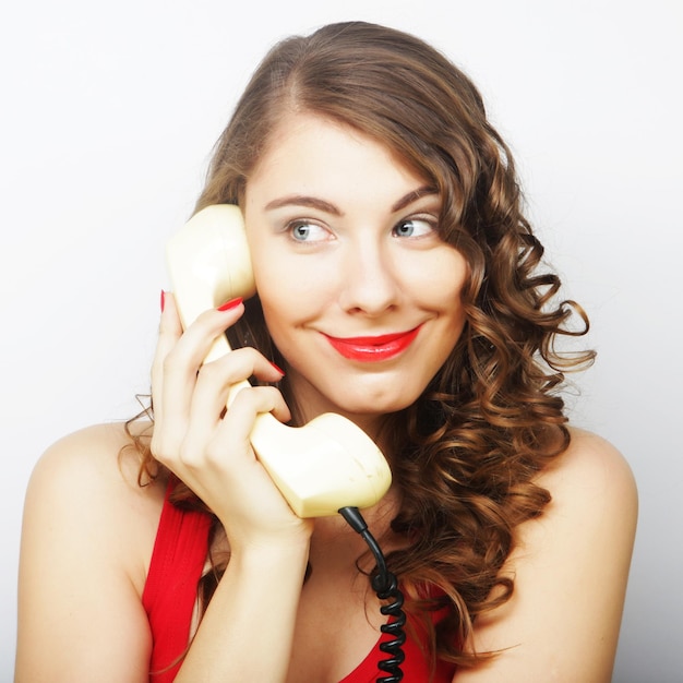 Mulher jovem com telefone antigo