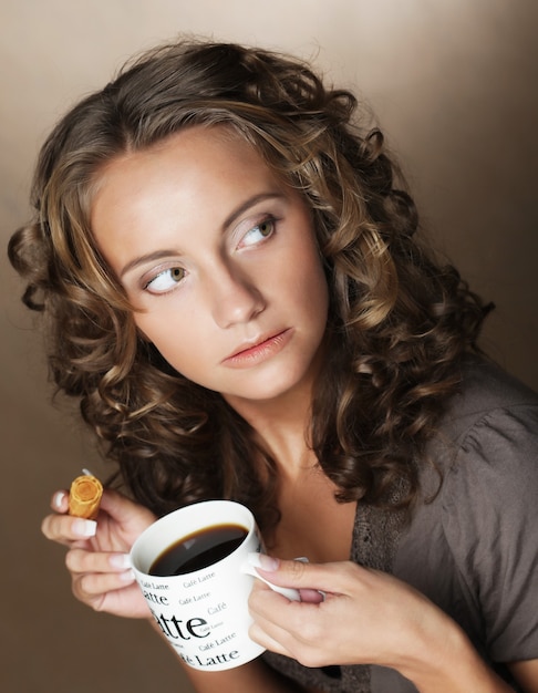 Mulher jovem com um café aromático nas mãos