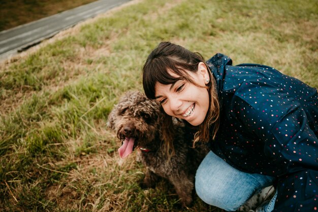 Mulher jovem com um casaco e um cão