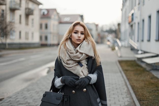 Mulher jovem com um casaco e um lenço na cidade