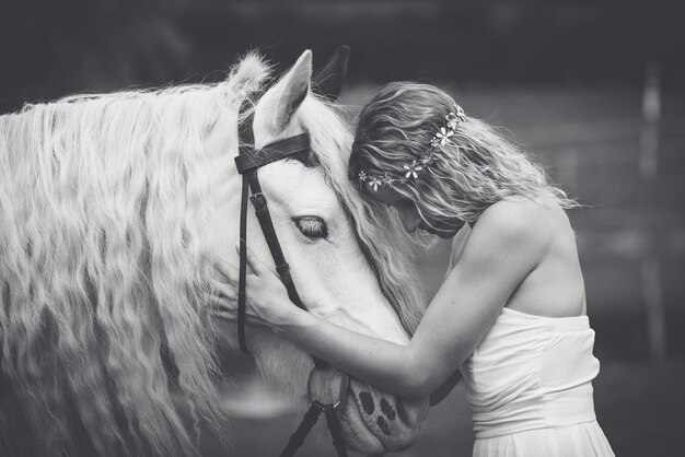 Foto mulher jovem com um cavalo branco