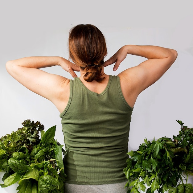 Mulher jovem com um conjunto de ingredientes verdes alface espinafre para uma dieta saudável