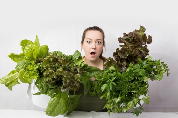 Mulher jovem com um conjunto de ingredientes verdes alface espinafre para uma dieta saudável
