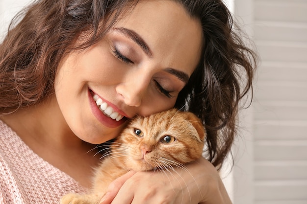 Foto mulher jovem com um gato engraçado fofo em casa