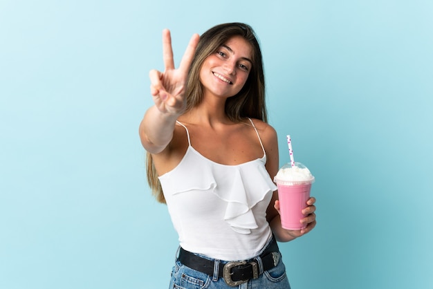 Mulher jovem com um milkshake de morango