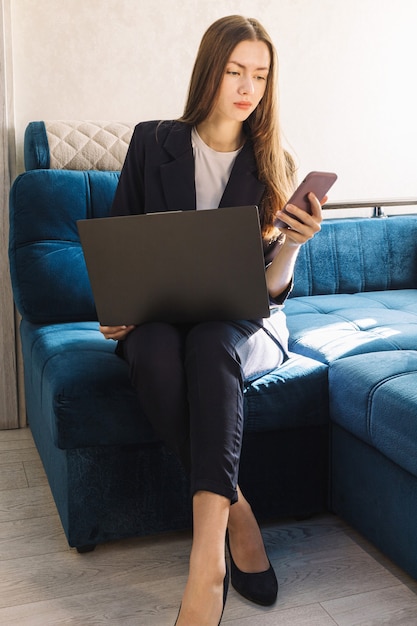 Mulher jovem com um notebook está estudando ou trabalhando em casa e ligando