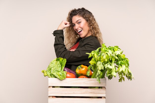 Mulher jovem com uma caixa de legumes