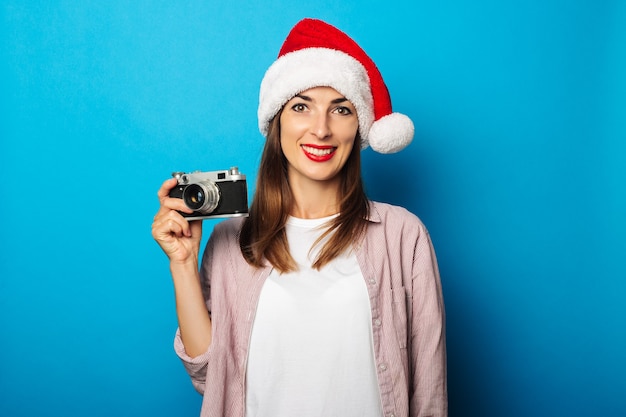 Mulher jovem com uma camisa e um chapéu de papai noel