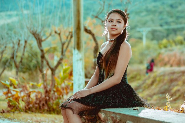 Mulher jovem, com, vestido preto, posar, parque