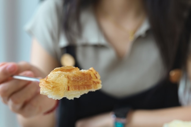 Mulher jovem comendo croissants em um café