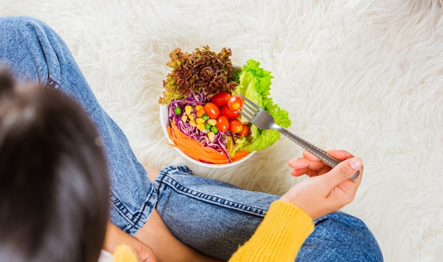 Mulher jovem comendo salada fresca