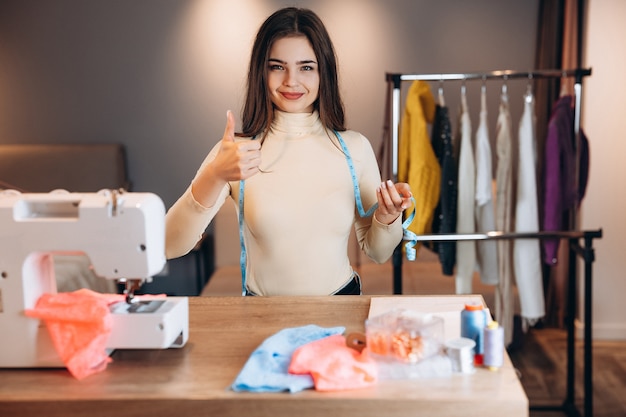 Mulher jovem costureira com máquina de costura