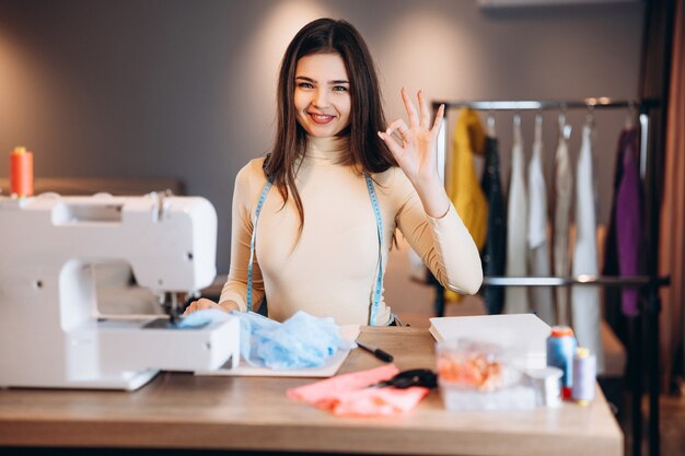 Mulher jovem costureira com máquina de costura