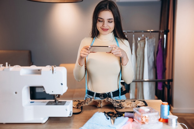 Mulher jovem costureira com máquina de costura