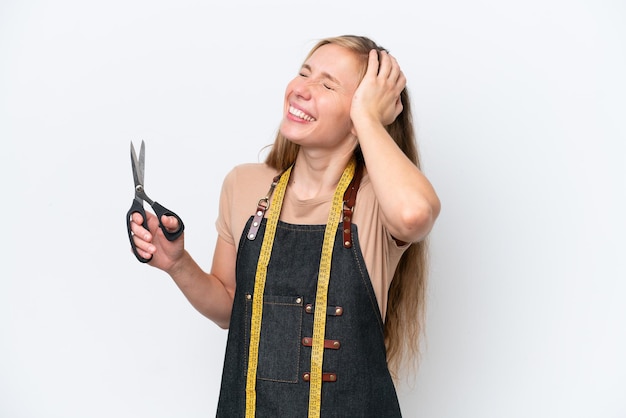 Mulher jovem costureira loira isolada no fundo branco sorrindo muito