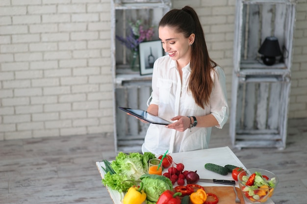 Mulher jovem cozinhando salada de vegetais saudáveis