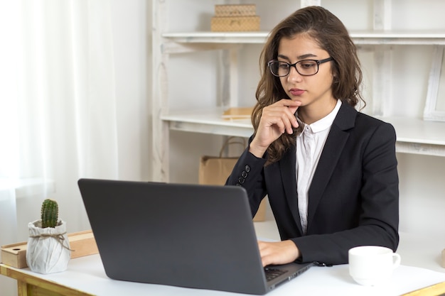 Foto mulher jovem de negócios indiano sentado na mesa do escritório